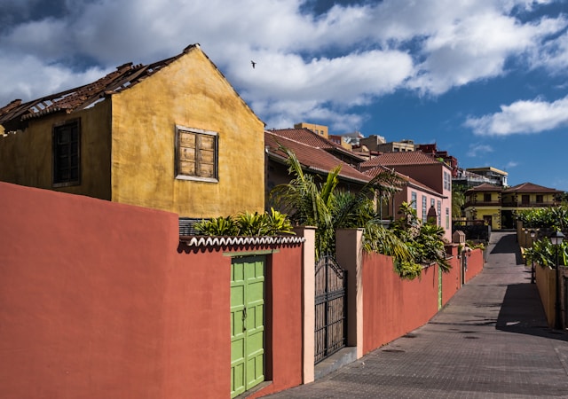 A vibrant street with colorful buildings and a clear blue sky, depicting urban architecture.