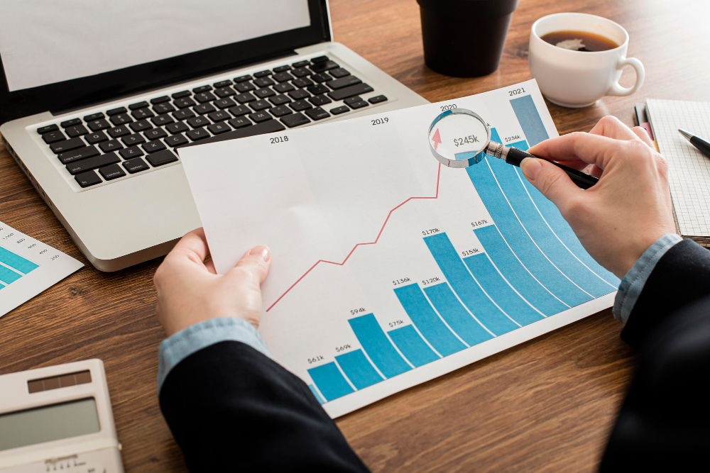 A professional reviewing financial growth charts with a magnifying glass, highlighting precise data points.